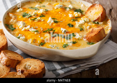 Hausgemachte heiße Buffalo Chicken Dip mit Crostini close up in der auflaufform auf den Tisch. Horizontale Stockfoto