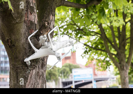 In der Nähe von Flying White Drone Absturz auf Baumstamm Stockfoto