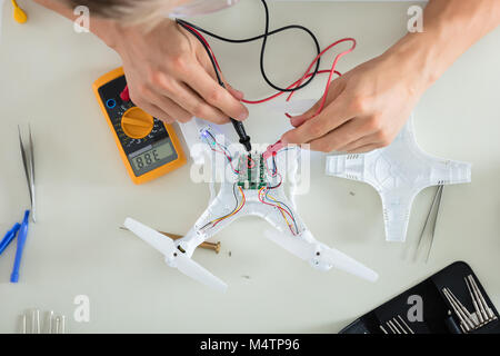 Nahaufnahme eines Mannes Prüfung elektrischer Strom von zerlegt Drone mit Multimeter Werkzeug Stockfoto