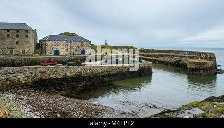 Malerischen kleinen Hafen, als Drehort, Portsoy, Moray, Schottland, Großbritannien, mit Hafen Pier, Hummer, Töpfe, alte Gebäude aus Stein und Ruderboot Stockfoto