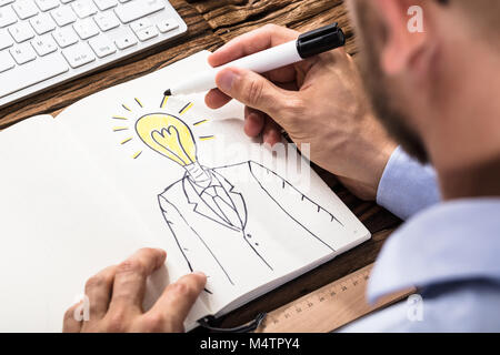 Nahaufnahme der Unternehmer eine Person mit beleuchteten Lampe Kopf auf Notebook Stockfoto