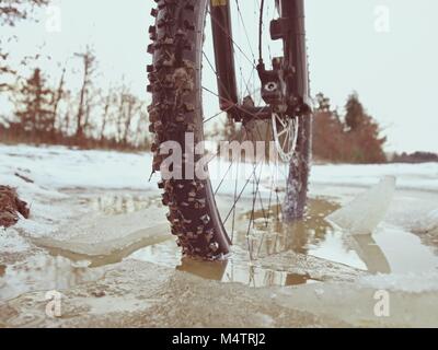 Vorderrad der Mtb im Ivy Pool gesperrt, extreme Radfahren im Winter Im Winter Landschaft. Defektes Stück eisscholle zwischen den Speichen. Stockfoto