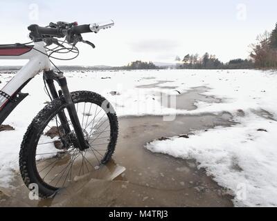 Vorderrad der Mtb im Ivy Pool gesperrt, extreme Radfahren im Winter Im Winter Landschaft. Defektes Stück eisscholle zwischen den Speichen. Stockfoto