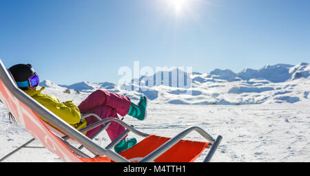 Bild der sportlichen Frau in Helm auf verschneiten Resort sitzen Stockfoto