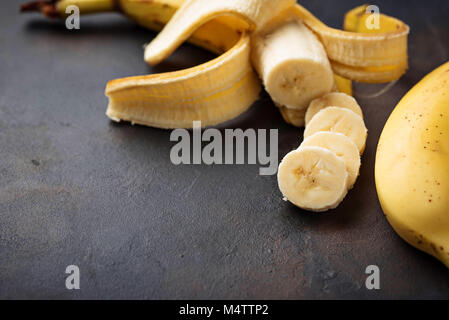 Frische Bananenscheiben auf dunklem Hintergrund Stockfoto