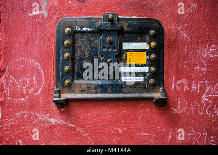 Berlin-Mitte, Prenzlauer Berg. Ungewöhnliche Innenhof detail. Eintrag System mit Namen und Türklingeln auf rostigen Platte auf rote Wand Stockfoto