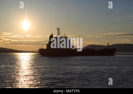 Behälter gegen einen Sonnenuntergang, die Berge und das Meer. Stockfoto