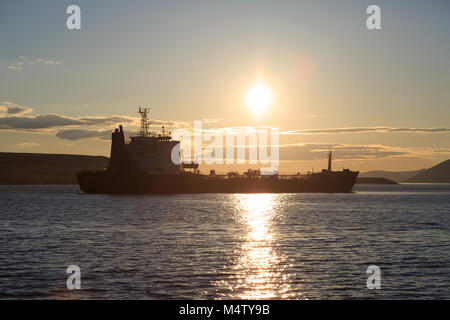 Behälter gegen einen Sonnenuntergang, die Berge und das Meer. Stockfoto