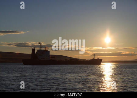 Behälter gegen einen Sonnenuntergang, die Berge und das Meer. Stockfoto