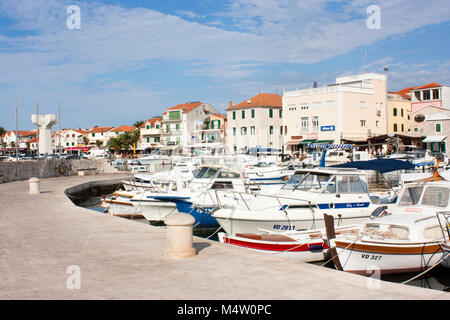 Vodice, Kroatien - 17. August 2016: Boote bis zum Pier gebunden, mit Promenade, Häuser, und WW2 Monument im Hintergrund Stockfoto