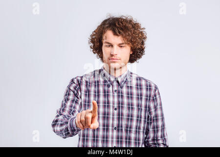 Curly Kerl ernst Finger drückt die Taste. Stockfoto