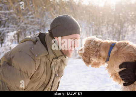 Mann spielt mit Cocker Spaniel im Freien Stockfoto