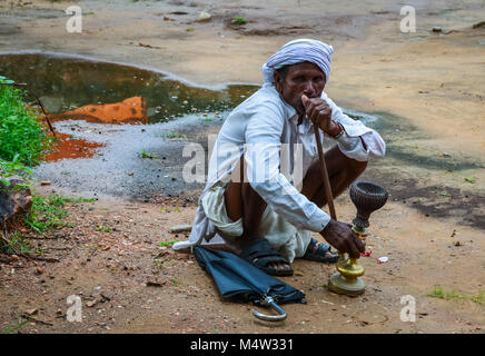 Indische Männer Rauchen einer Wasserpfeife auf dem Boden in einem ländlichen Dorf in der Nähe von Jaipur, Indien hocken. Stockfoto