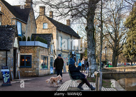 BOURTON AUF DEM WASSER, UK - 15. FEBRUAR 2018: alte Häuser und Geschäfte in Bourton-on-the-Water, einem Dorf in der Grafschaft Gloucestershire in Cotswolds Stockfoto