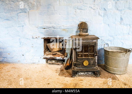 Vintage altmodische Coalbrookdale Kohle Kaminofen und Zink Eimer in einem Gebäude in Painswick Rococo Garten, Painswick, Gloucestershire Cotswolds Stockfoto