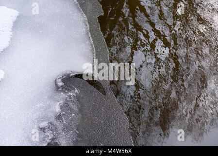 Ansicht von oben von Eis Zurückfliehend und Wasser im frühen Frühjahr fließt Stockfoto