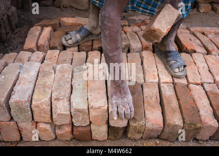 Ein Mann Stapeln von Ziegelsteinen in Varanasi, Indien. Stockfoto