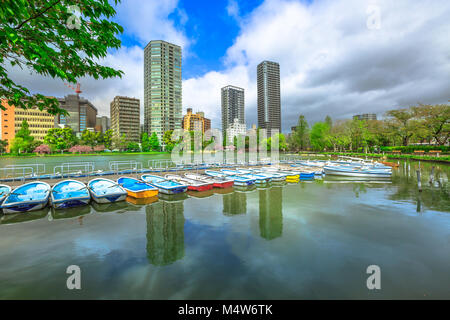 Tretboote und Tokio Wolkenkratzer auf shinobazu Teich in Ueno Park, einen öffentlichen Park neben Ueno Station im Zentrum von Tokyo widerspiegelt. Ueno Park ist das Beste in Tokio für Kirschblüten betrachtet. Stockfoto