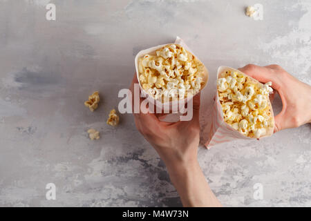 Golden caramel Pop Corn in Tüten in den Händen, Ansicht von oben. Stockfoto