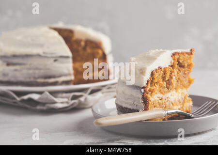 Karotte hausgemachte Kuchen mit Weiß Creme auf grauem Hintergrund. Festliches dessert Konzept. Stockfoto