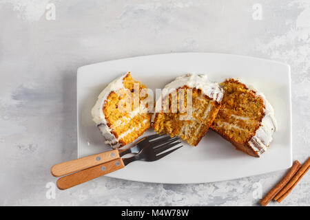 Stück hausgemachter Karottenkuchen mit weißer Creme auf die weiße Schale. Festliches dessert Konzept. Stockfoto