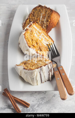 Stück hausgemachter Karottenkuchen mit weißer Creme auf die weiße Schale. Festliches dessert Konzept. Stockfoto