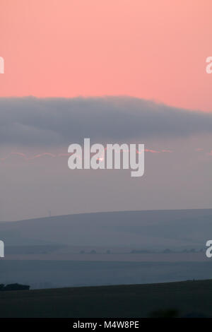 Sun verschwinden hinter Wolken bei Sonnenuntergang Stockfoto