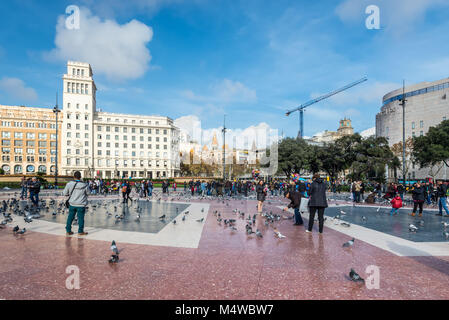 Barcelona, Spanien - 5. Dezember 2016: Touristen füttern die Tauben auf dem Platz von Katalonien (Placa de Catalunya) in Barcelona. Plaza de Catalunya ist eine Stockfoto