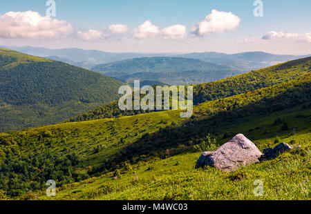 Felsbrocken auf dem Hügel. berg Sommer Landschaft. Wiese mit riesigen Steinen unter dem Gras auf der Spitze des Hügels Stockfoto