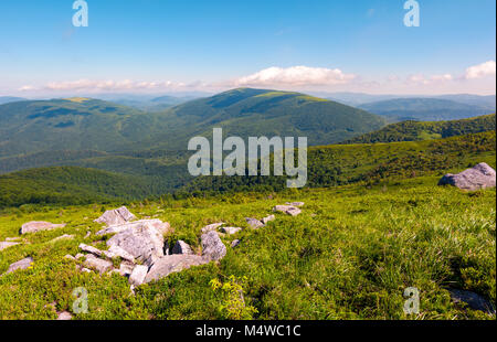 Felsbrocken auf dem Hügel. berg Sommer Landschaft. Wiese mit riesigen Steinen unter dem Gras auf der Spitze des Hügels Stockfoto