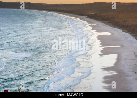 Suchen von Byron Bay Leuchtturm über den südlichen Strand als Fischer Fische unter die untergehende Sonne zu fangen versuchen. Stockfoto