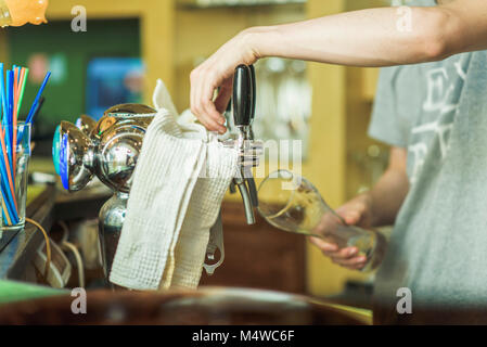 Barkeeper gießen frisches Bier Stockfoto