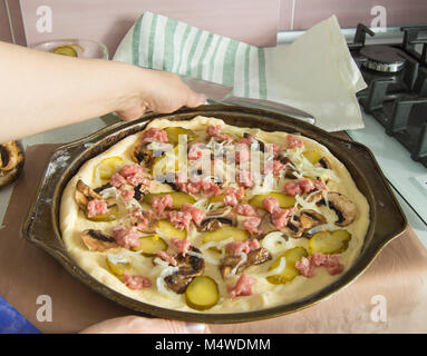 Weibliche Hände halten eine Pizza formen, backen. Stockfoto