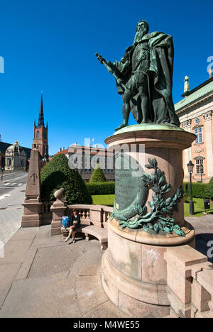Bronzestatue von Gustavo Erici vor der Riddarhuset (Haus des Adels), im Hintergrund der Belfried von Riddarholm Kirche, Stockholm, Schweden Stockfoto