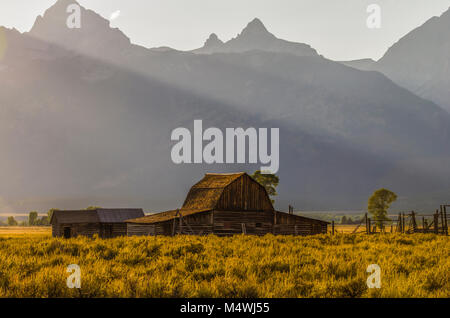 Die letzten Sonnenstrahlen über den Teton Mountsins form Schichten von Licht über die moulton Scheune Stockfoto