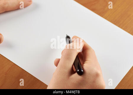 Weibliche Hände halten kalligrafischen Pinsel oder Stift, mit weißen Papier - mit Platz für Text Stockfoto