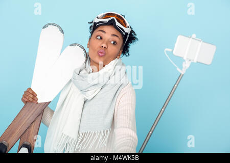 Junge afrikanische Frau an der blauen Wand studio Winter Sport Ski isoliert die Bilder Stockfoto