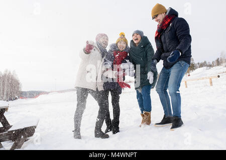 In voller Länge Porträt von zwei junge Paare glücklich Lachen Spaß draußen Schnee werfen, kopieren Raum Stockfoto