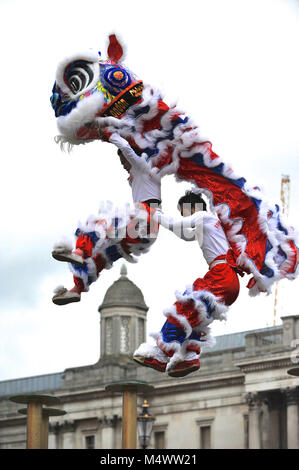 Akrobaten gekleidet als zeremonielle Lions im Rahmen einer Flying Lion Dance in Trafalgar Square als Teil der chinesischen Neue Jahr Feiern in London, England, Vereinigtes Königreich. In diesem Jahr wird die Ankunft des Jahres des Hundes, der elften Tier im chinesischen Tierkreis. Hunde sind besonders günstig, da sie symbolisieren das Kommen des Vermögens, und die im Jahr des Hundes geboren sind, sagte freundlich zu sein, ehrlich, treu und zuverlässig ist. Quelle: Michael Preston/Alamy leben Nachrichten Stockfoto