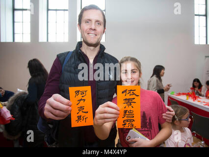 Toronto, Kanada. 18 Feb, 2018. Ein Mann und seine Tochter für Fotos mit ihren chinesischen Namen in chinesischer Kalligraphie während der 2018 Toronto Happy Chinese New Year Rezeption & Familie Tag Wochenende im Royal Ontario Museum (ROM) in Toronto, Kanada, Feb.18, 2018 darstellen. Mit Chinesischen papercut, Kalligraphie, Lion Dance und vieles mehr. Dieses jährlichen Chinesischen neue Jahr Ereignis begann am Sonntag Hunderte von Besucher zu zeichnen das chinesische Mondjahr des Hundes im Royal Ontario Museum in Toronto zu feiern. Credit: Zou Zheng/Xinhua/Alamy leben Nachrichten Stockfoto