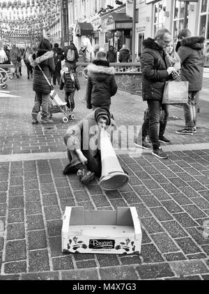 Schwarz & Weiß Fotografie ein strassenmusikant spielt eine Leitkegel, China Town, London, England, UK. Credit: London Snapper Stockfoto