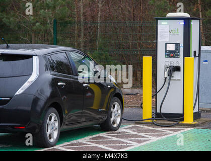 Ein Nissan Leaf Elektroauto mit einem Tri-Schnellladegerät an einem Elektrofahrzeug Ladestation, Riccarton, Edinburgh. Stockfoto