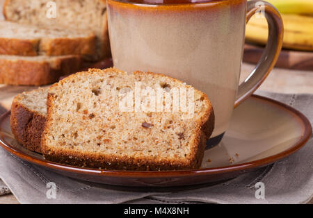 Scheibe Banane Mutter Brot auf einem Teller mit einer Tasse Kaffee Stockfoto