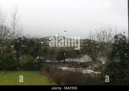 Blick auf die Berge AUSSERHALB VON DUBLIN IRLAND MIT WASSERTROPFEN AUF DAS GLAS an einem regnerischen Tag. Typischen IRISCHEN WETTER IM FEBRUAR Stockfoto