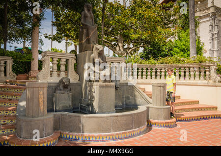 Junge bewundert Statue von Sekhmet, ägyptische Göttin mit dem Kopf eines Löwen und den Körper einer Frau an Hearst Castle, San Simeon, CA. Stockfoto