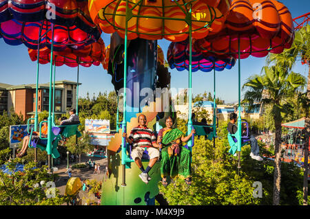 Indische Paare, die Frau, gekleidet in einem grünen Sari, reiten Sie die Jumpin' Quallen paratower Fallschirm Fahrt im Disneyland in Kalifornien. Stockfoto