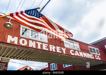 Das Monterey Canning Firmengebäude mit der amerikanischen Flagge im Vordergrund auf bewölkten Tag, Monterey, Kalifornien. Stockfoto