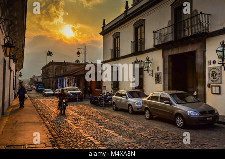 Die untergehende Sonne wirft goldenen Glanz auf der Straße mit Kopfsteinpflaster in der Alten Welt Antigua. Stockfoto