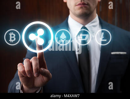 Geschäftsmann drücken Welligkeit Symbol Auswahl aus anderen cryptocurrency. Bitcoin, Welligkeit, litecoin, Bindestrich, des Astraleums Stockfoto