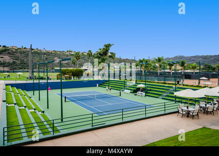 Carlsbad, CA, USA. Helle grüne Tennisplätze mit Stadion Sitze mit Gras und ein paar Zuschauern gefüllt. Stockfoto